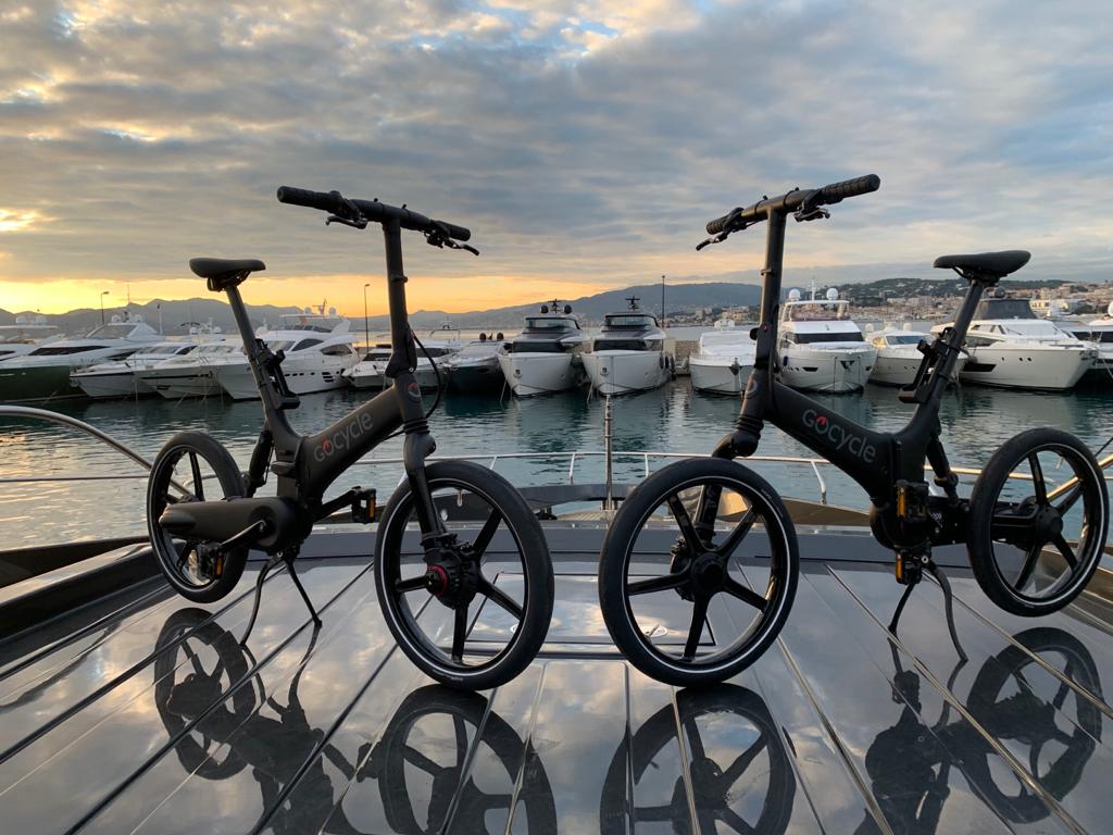 Deux vélos électriques pliants Gocycle à bord d'un yacht au coucher du soleil, solution de mobilité nautique de la gamme Gocycle et Gocycle G5